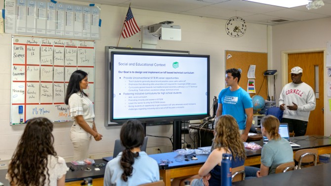 Cornell students presenting in high school classroom