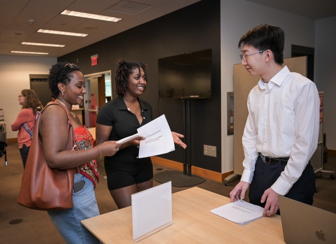 Di Tian talks to student attendees at the Global Scholars showcase. 