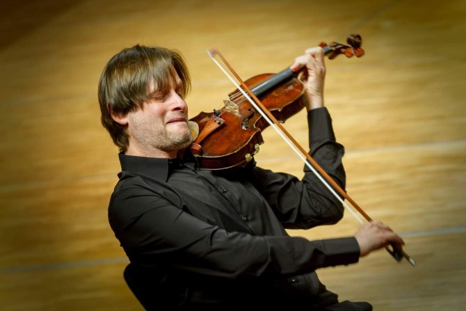 Person playing a violin passionately 