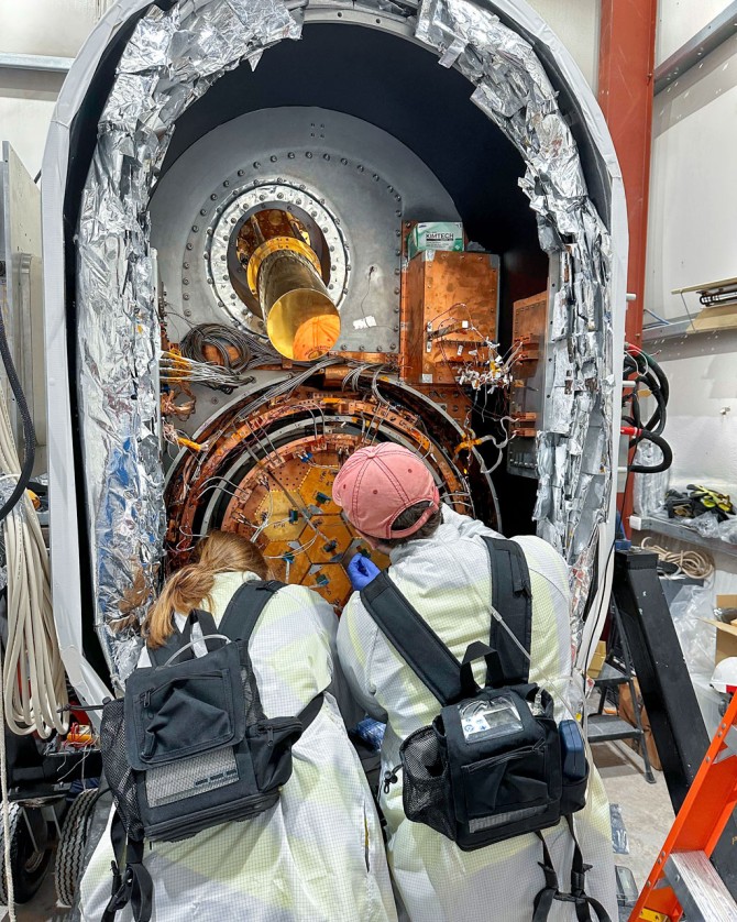 Doctoral candidate Ben Keller and Princeton collaborator Suzanne Staggs install a detector array into one of the Simons Oservatory small aperture telescopes last October.