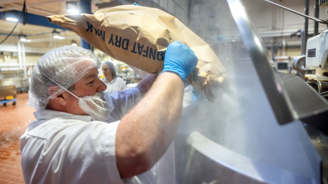 Jon Fish, a technician in the Food Processing and Development Laboratory, adds powdered nonfat milk to the beverage.