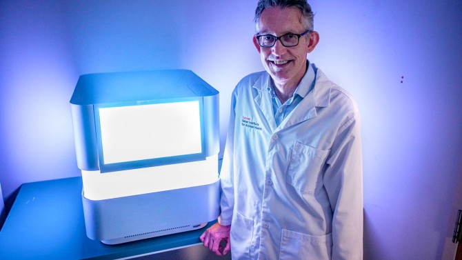 Dr. Gary Whittaker, the James Law Professor of Virology in the departments of Microbiology and Immunology and of Public and Ecosystem Health, stands in front of the NextSeq 1000.