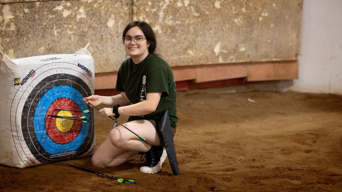 Junior archery instructor Bella Hanson, 15, of Saratoga County, collects arrows after target practice.