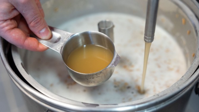 Dean Hauser shows a sample of the wort, which is the liquid extracted from grains during the mashing process. It consists of water, sugars, amino acids and proteins.