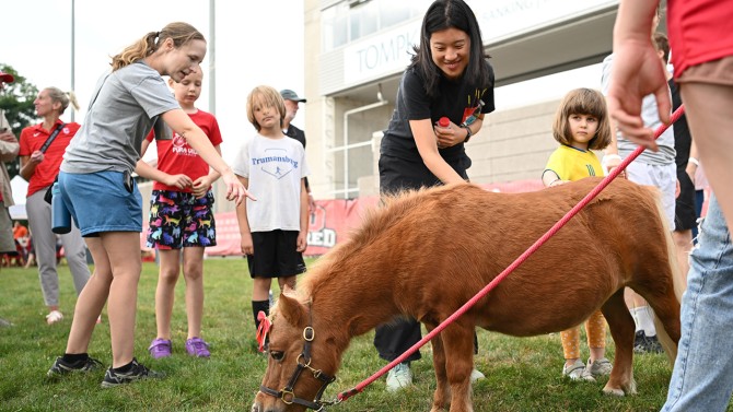 Members of the Cornell Community greet and pet Minnie, the mini horse.