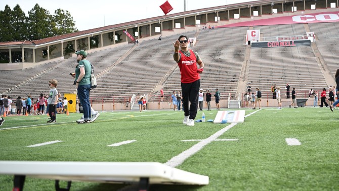 A Cornell student plays cornhole at the yard games station.