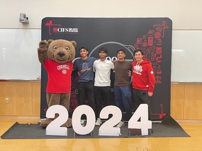 four students with Touchdown the Bear