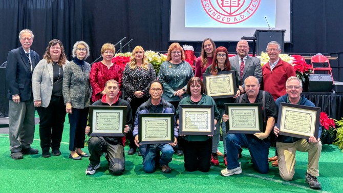 Winners of 2024 Bartels Awards for Custodial Service were, holding certificates, from left to right, Paul Taggart; Dhondup “DD” Zurkhang; Dawn Smith; Tina Fritts (standing); Jeff Davis; and Mike Halderman. At far left is Phil Bartels ’71, with Susan Bartels third from left.