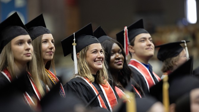 Graduates stood as their degrees were conferred by leaders of each college.