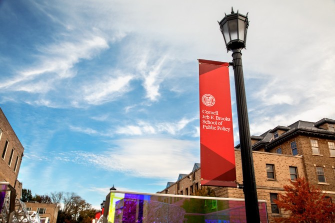 Lampost with a red banner on it: Cornell Jeb E. Brooks School of Public Policy 