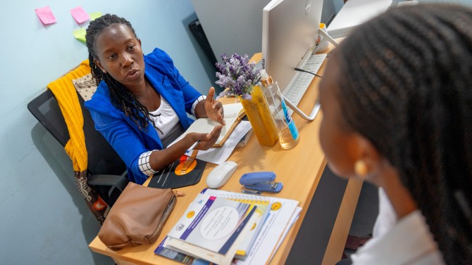 Anea Isaka Lizonga, director of the “gender desk” at the Catholic University of Health and Allied Sciences, talks with a student about her office’s services.