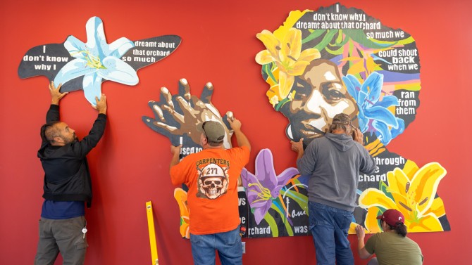 Wright, left, works with members of Cornell Facilities to install the tableaux section featuring Toni Morrison. The text is from Morrison's short story, "Recitatif."