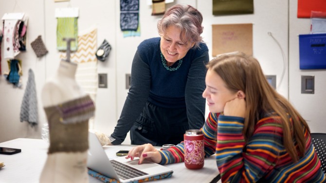 Melissa Conroy, senior lecturer of human centered design in CHE, reviews work with teaching assistant Madison Feely ’26, a fiber science and apparel design major, during the Knitwear Design and Other Applications class.