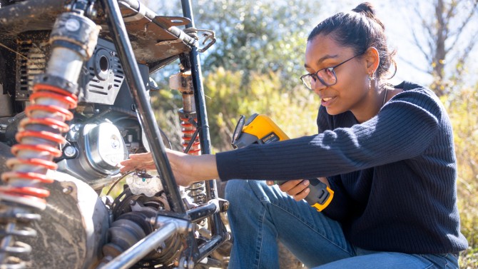 Maya Chakraborty ’27, mechanical engineering major and 2025-26 drivetrain lead, makes adjustments to the previous season’s car during a test run at the team’s practice track.