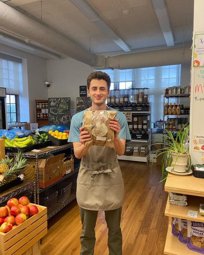 person holding loaf of bread in grocery store
