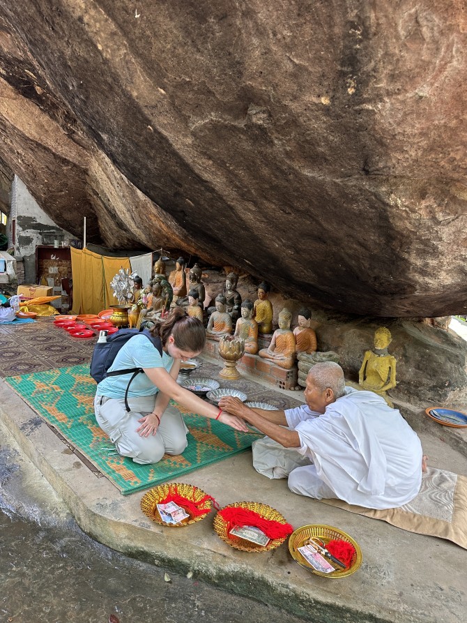 Emma Alexander bows on her knees while a nun holds her outstretched hand.