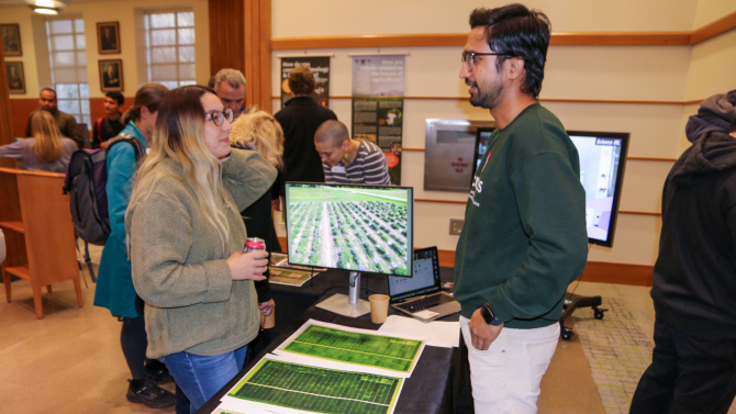 Graduate Student Dinesh Ghimire talks imaging with attendee.