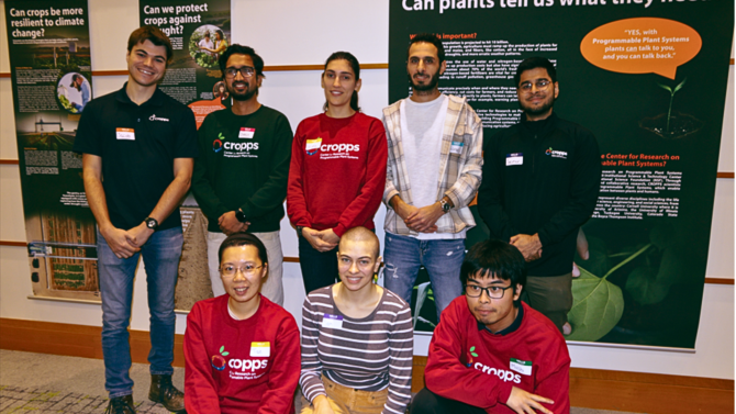 CROPS team members posing in front of exhibit