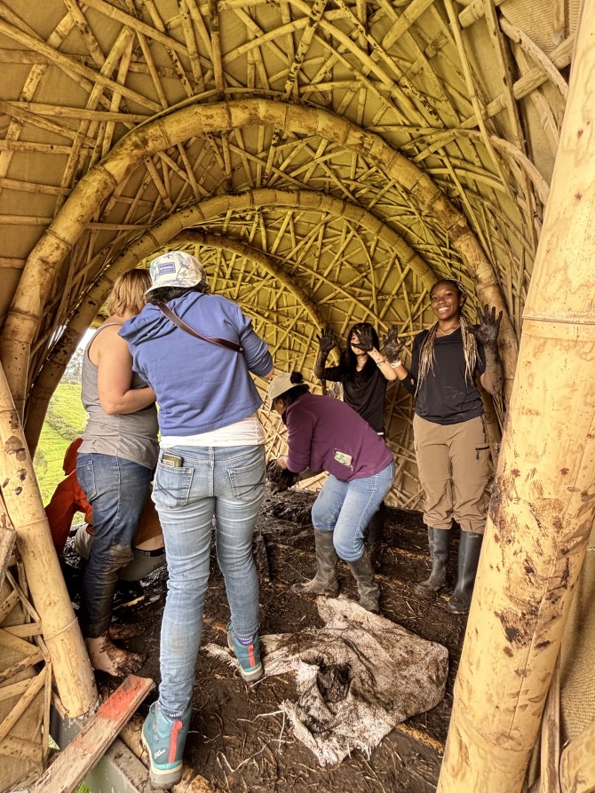 Laidlaw scholars with muddy hands help to build a wooden structure.