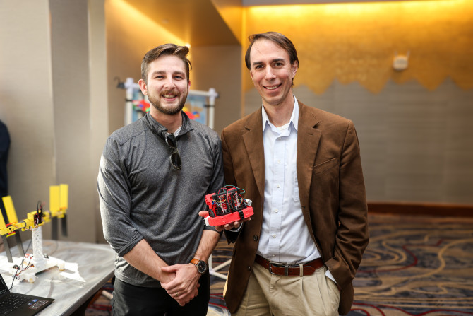 two people standing with a robot in between