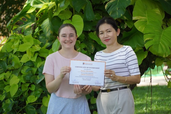 Emma Alexander and her supervisor pose for a photo, both holding up Emma's internship certificate.