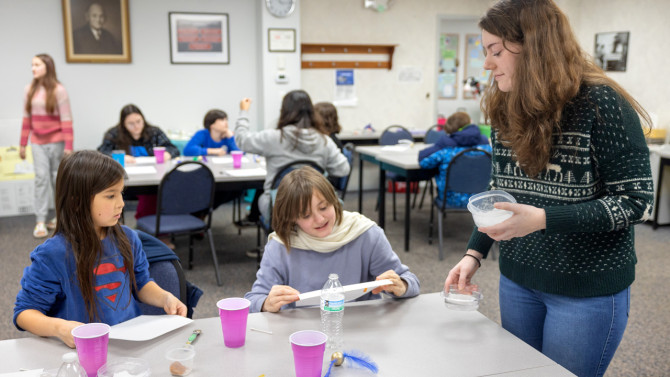 Gabrielle Dion (right), 4-H CARE wellness educator at Cornell Cooperative Extension Jefferson County, leads a group of students in a STEM activity in Watertown, New York, on Nov. 18. 