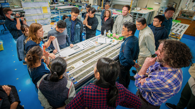Patrick Fulton, right, associate professor of earth and atmospheric sciences at Cornell Engineering, and scientists aboard the drilling ship Chikyu observe core samples retrieved from the Japan Trench.