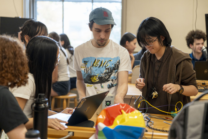 Students gather around a beach ball as part of a physics experiment. 