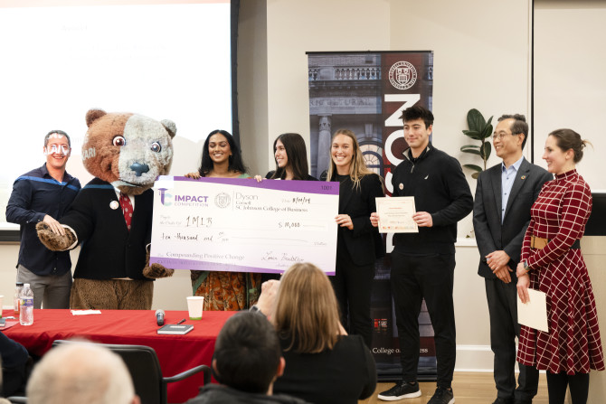 A group of students receive an award at the Dyson Grand Challenges Impact Competition. 