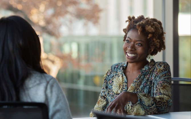 professor smiles talking to a student
