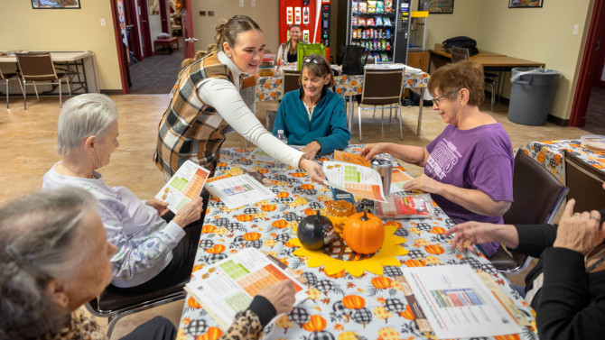 Taylor Rollins, nutrition educator for CCE Jefferson County, distributes information on whole grains to participants in the North Country Fruit and Vegetable Prescription Program, in Watertown, New York. From left, Doris Mitchell, Gail Parsons, Rollins, Laura Paddock and Kathie Crescenzi. 