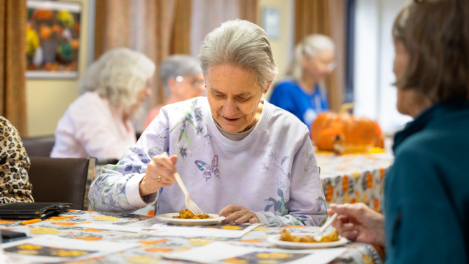 Gail Parsons of Watertown, New York, digs into a healthy peach and pear cobbler with a whole-grain granola topping at a session of the North Country Fruit and Vegetable Prescription Program.