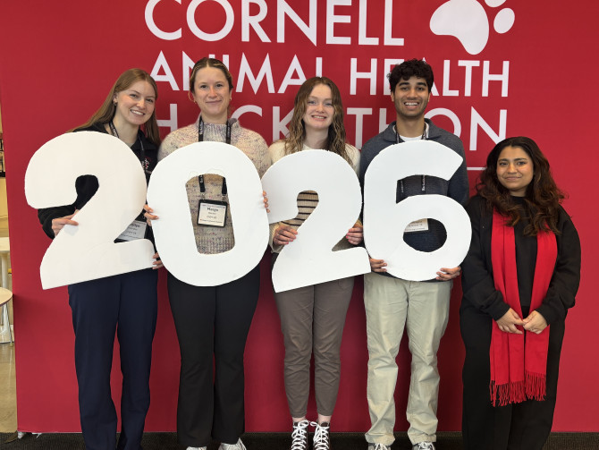 five people in front of a hackathon banner