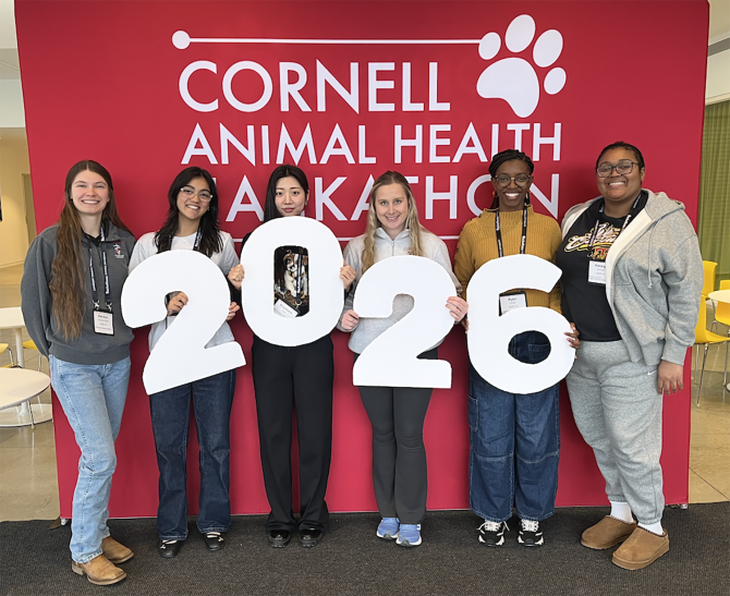 six people in front of a banner