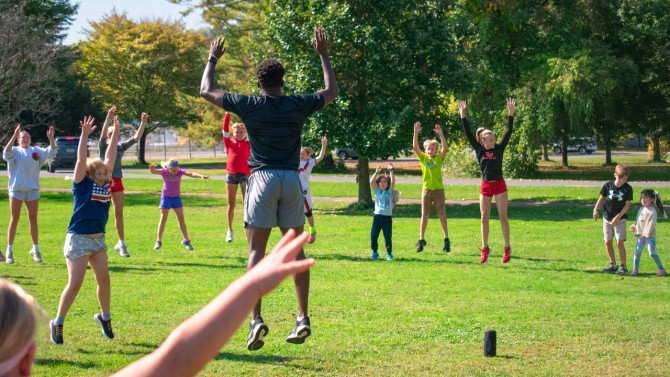 Abraham Ailemen ’26 leads jumping jack warmups.
