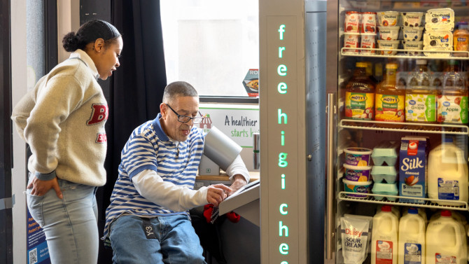 Moet Grooms (left), a CCE Erie educator with CCE's Healthy Community Store Initiative, helps Jay Echevarria check his blood pressure at Buffalo's Golden Corner store in Buffalo, New York.