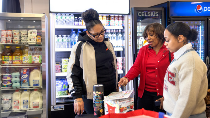 Sheila Bass (center), program manager of CCE Erie's Healthy Community Store Initiative, talks about nutrition with Jasmine Robbs (left), a customer at Buffalo's Golden Corner store, and Moet Grooms (right), a CCE educator with the Healthy Community Store Initiative, in Buffalo, New York.