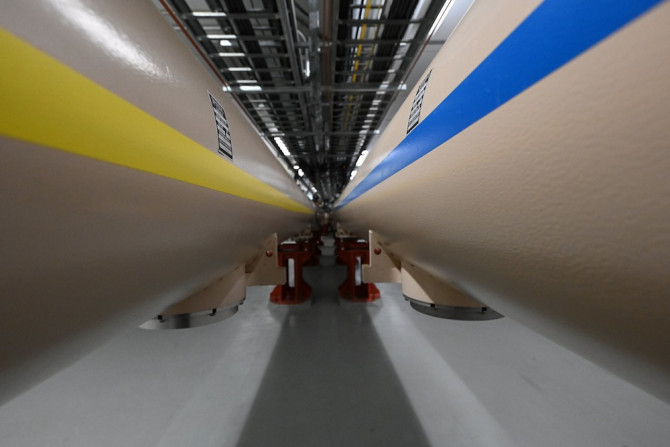 Close up of two very large tubes: the one on the left has a yellow stripe, the one on the right has a blue stripe
