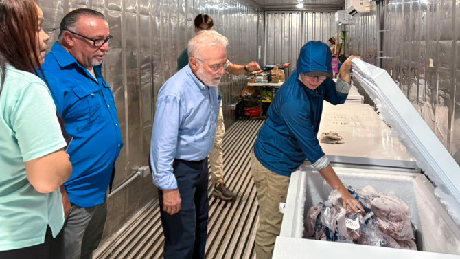 Héctor Abruña (center), the Emile M. Chamot Professor of chemistry and chemical biology in the College of Arts and Sciences, inspects food frozen with power from a mobile, solar-powered battery. Also pictured: Vice Mayor of Vieques Adolfo Rosa Miranda (left of Abruña) and Beth Straight ’22 (right).