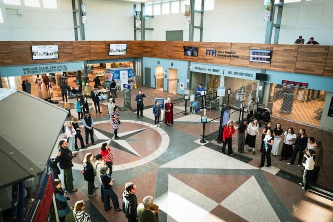 crowd watches singers in an airport atrium