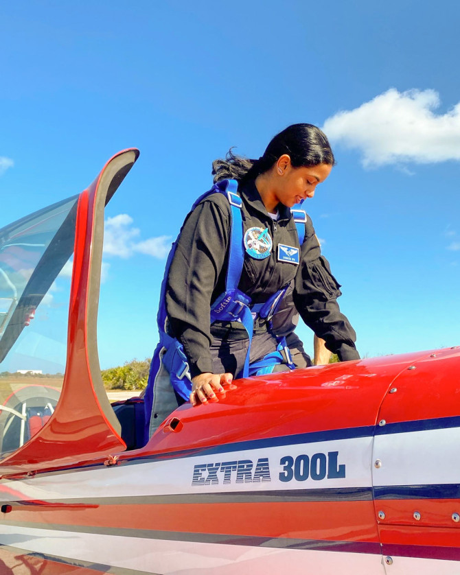 Abiram enters an Extra 300L airplane to practice aerobatic flight maneuvers in Cape Canaveral, Florida.