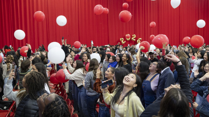 Red and white balloons rain down on the Class of 2026 near the conclusion of Senior Convocation.