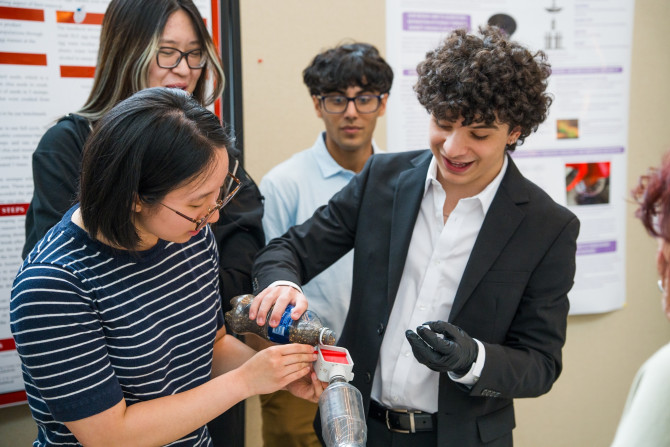 student pours liquid into a device