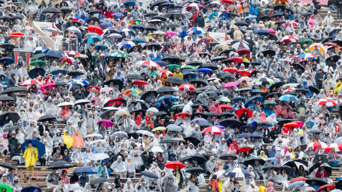 Audience in stands with umbrellas