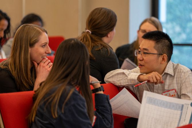 A group of graduate teaching fellows, include Kim Webb, blonde and wearing a black shirt, chat at a conference