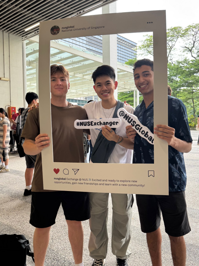 Kevin Chang poses for a photo with new friends in a large frame. 
