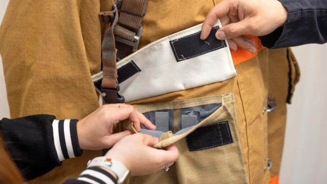 The detachable front pocket of the redesigned fire suit features compartments so tools can be custom-organized by the firefighter