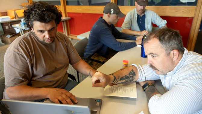 Warrior-Scholar Project student PJ Zieniuk, left, works with writing instructor Brehan Brady at a college readiness academic boot camp in Robert Purcell Community Center.
