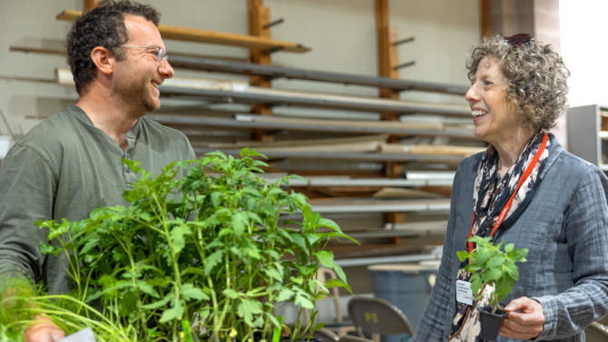 Laurie VanNostrand (right), Cornell Cooperative Extension master gardener coordinator in Wayne County and statewide coordinator for the Vegetable Variety Trial Garden project, chats with a master gardener volunteer at a plant pick-up day on campus on May 12. 
