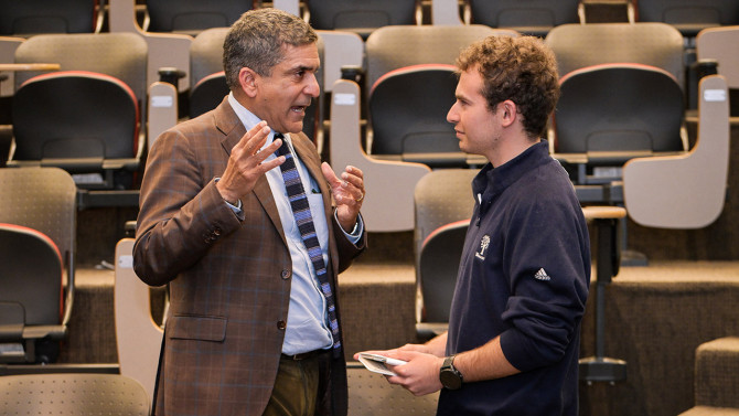 Khurana speaks with a lecture attendee.
